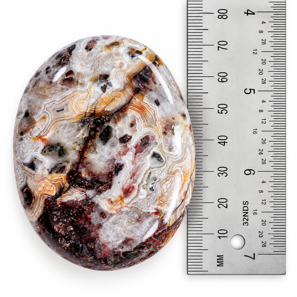 Crazy Lace Agate palm stone shown beside ruler for size reference