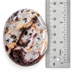 Crazy Lace Agate palm stone shown beside ruler for size reference