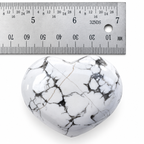 White Howlite heart palm stone with grey marbling beside metal ruler