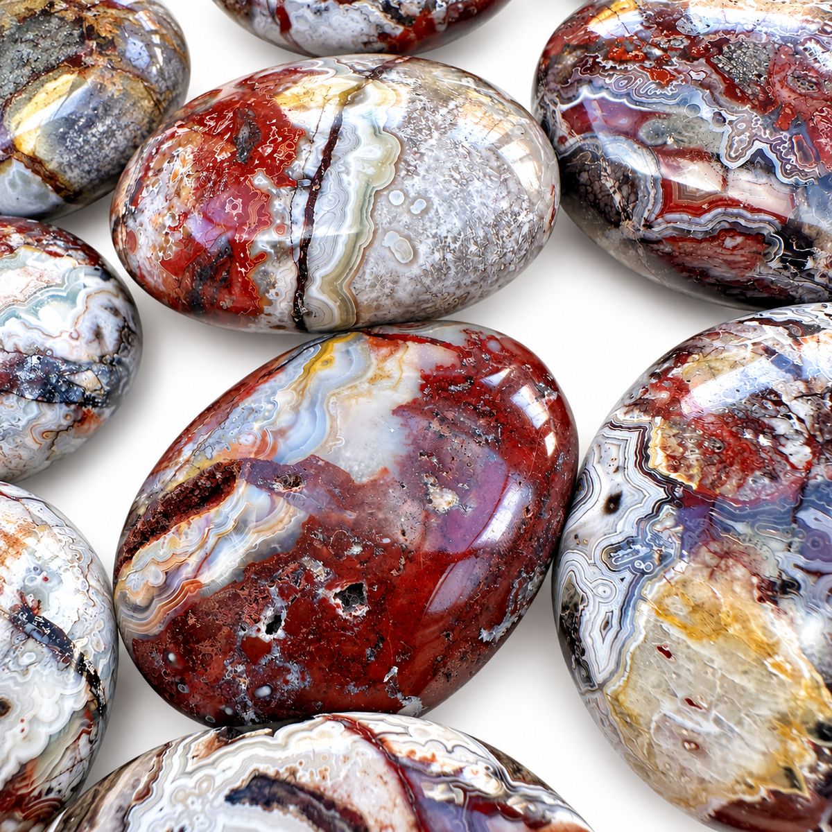 Group of polished Crazy Lace Agate palm stones showing natural variations
