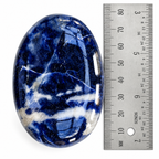 Blue Sodalite palm stone beside a ruler for size reference