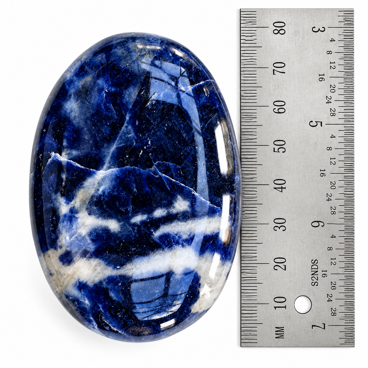 Blue Sodalite palm stone beside a ruler for size reference