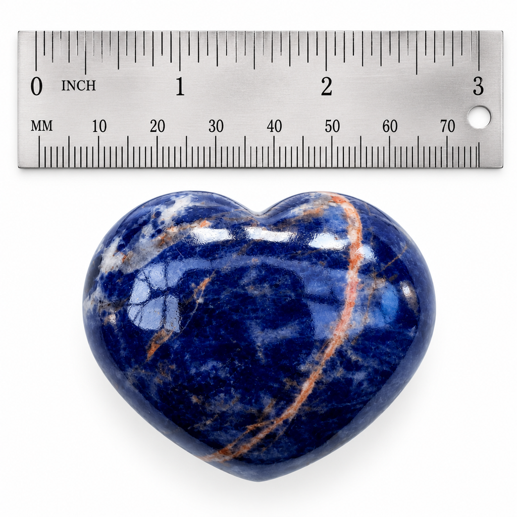 Polished blue Sodalite heart palm stone beside metal ruler for size reference