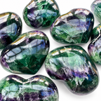 Close-up of polished Rainbow Fluorite crystal hearts with natural green and purple patterns