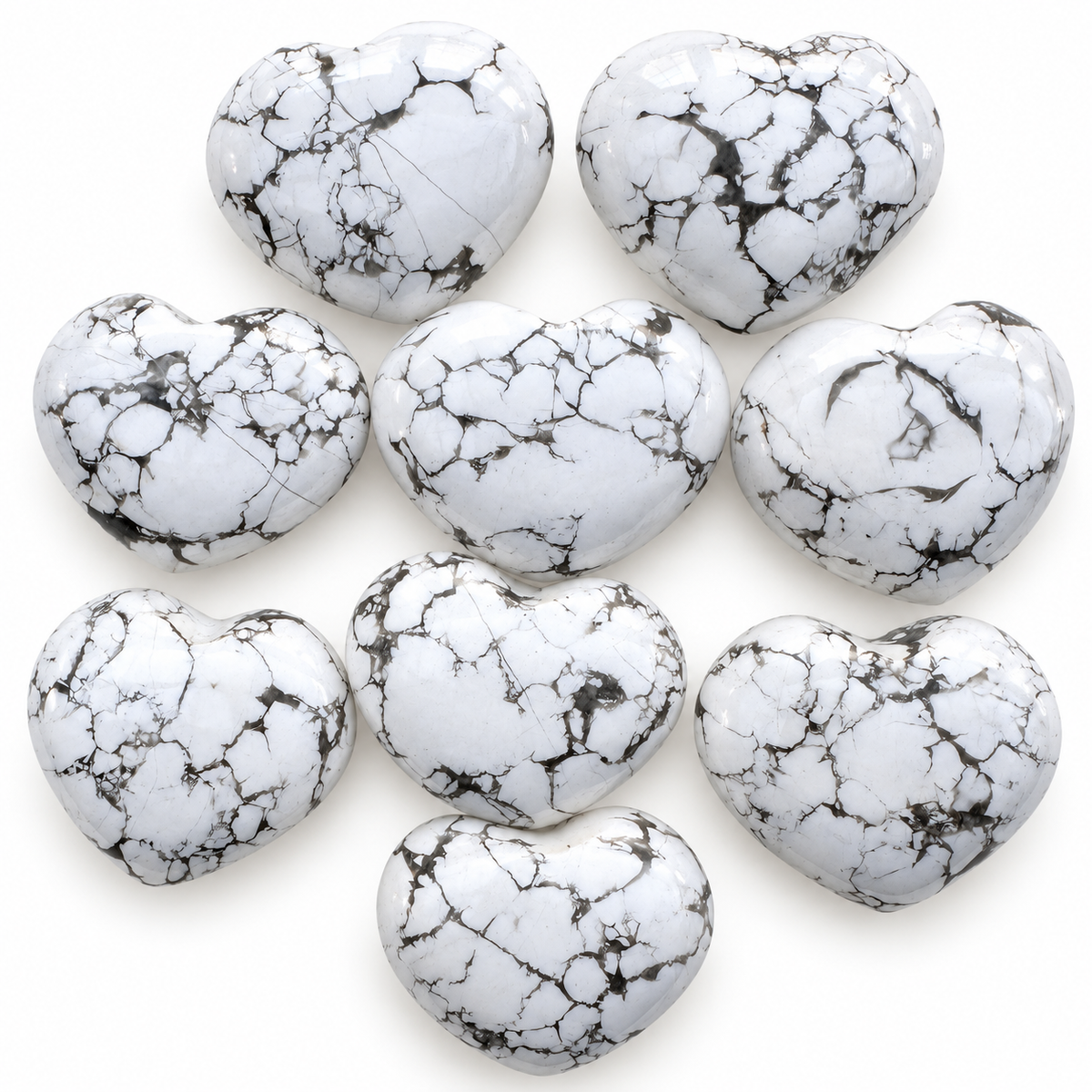 Group of polished Howlite heart-shaped palm stones showing natural variations