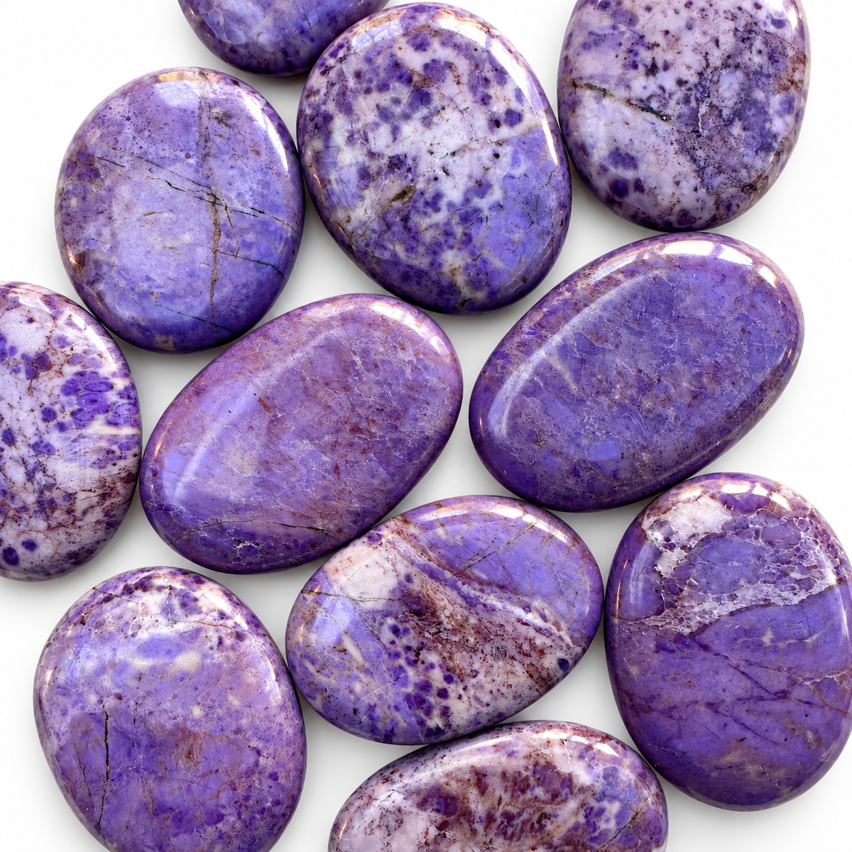 Group of polished Purple Jade palm stones showing natural variations
