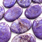 Group of polished Purple Jade palm stones showing natural variations