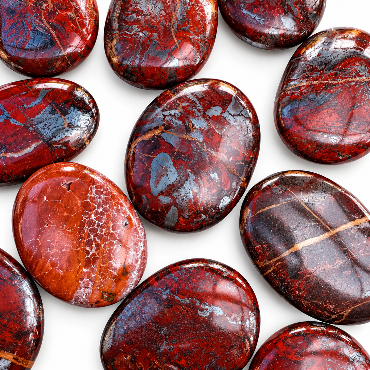 Collection of polished Red Jasper Hematite palm stones with natural variations