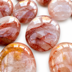 Group of polished Fire Quartz palm stones showing natural variations