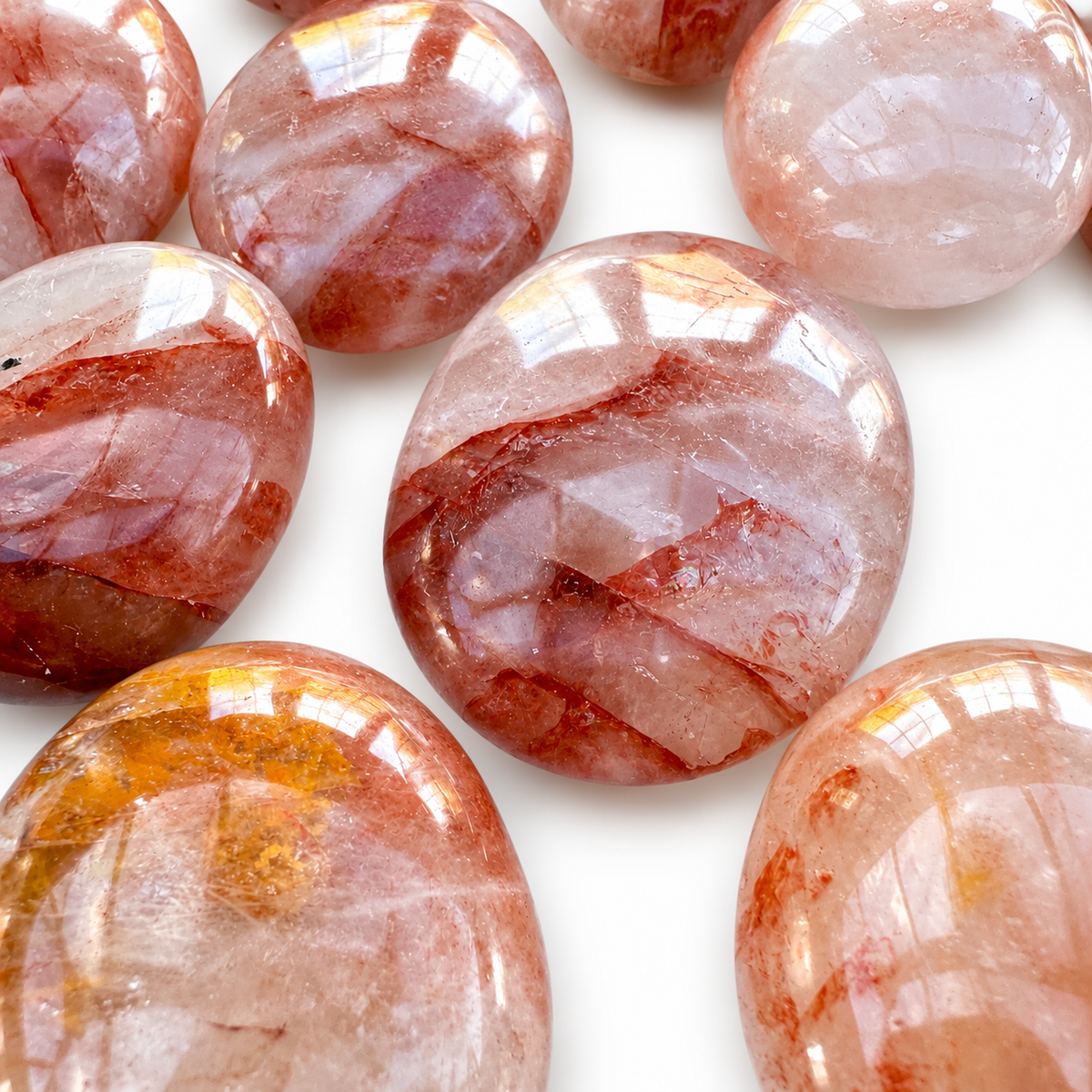 Group of polished Fire Quartz palm stones showing natural variations