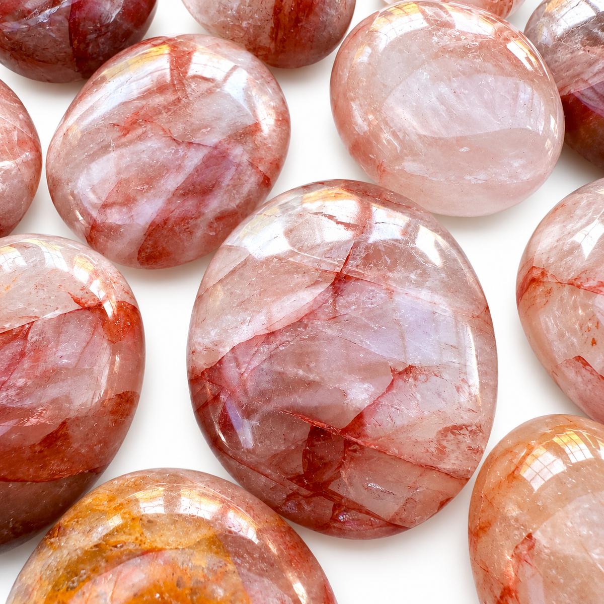Group of polished Fire Quartz palm stones showing natural variations