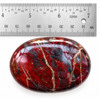 Red Jasper Hematite palm stone photographed with a ruler for size reference
