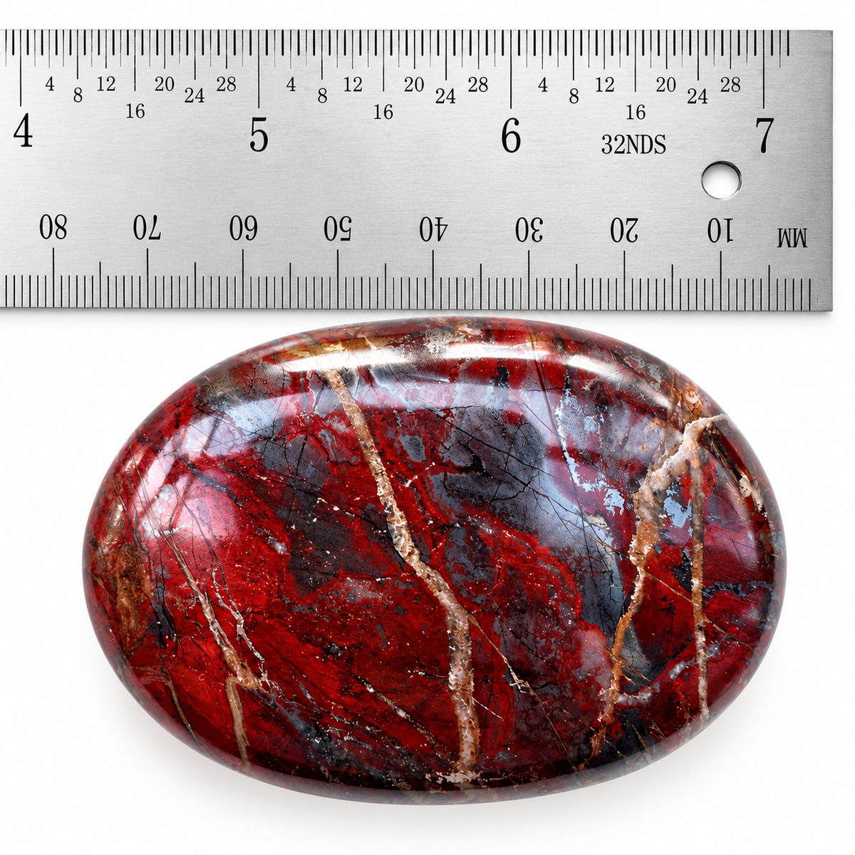 Red Jasper Hematite palm stone photographed with a ruler for size reference